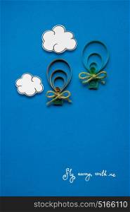 Creative concept photo of clouds and aerostats made of paper on blue background.