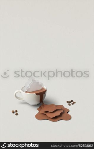 Creative concept photo of cup with splashing coffee made of paper on grey background.