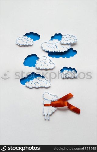 Creative concept photo of girl with clouds made of paper on white background.