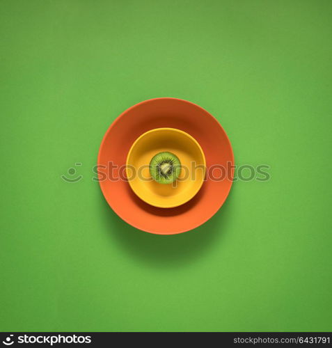 Creative concept photo of kitchenware, painted plate with food on it on green background.