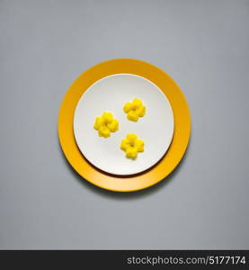 Creative concept photo of kitchenware, painted plate with food on it on grey background.