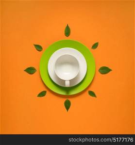 Creative concept photo of kitchenware, painted plate with food on it on orange background.