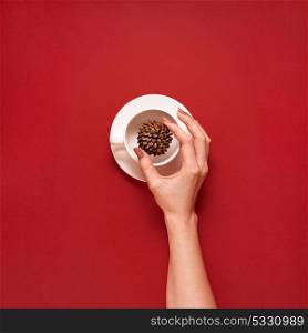 Creative concept photo of kitchenware with hand, painted plate with food on it on red background.