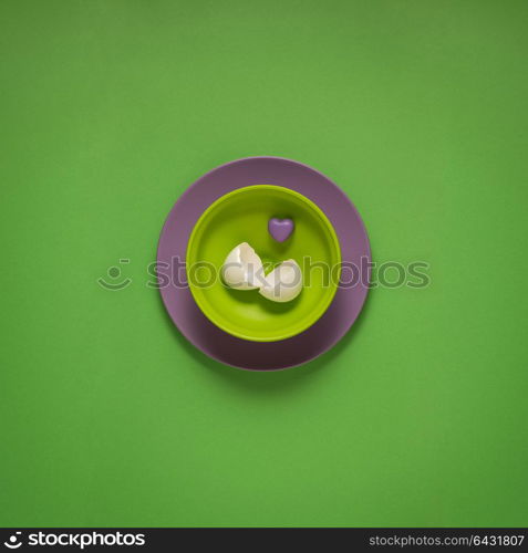 Creative concept photo of painted plates on green background.