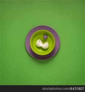 Creative concept photo of painted plates on green background.