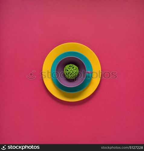 Creative concept photo of painted plates on pink background.