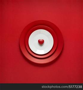 Creative concept photo of painted plates on red background.