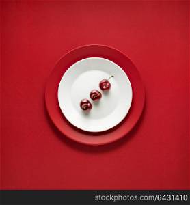 Creative concept photo of painted plates on red background.