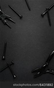 Creative concept photo of painted tools and nails on black background.