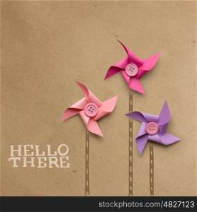 Creative concept photo of three wind mills made of paper on brown background.