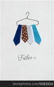 Creative concept photo of ties on a hanger made of paper on white background.