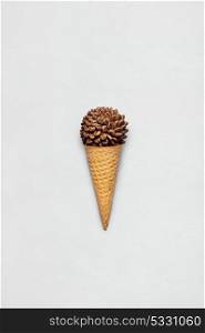 Creative concept photo of waffle cone filled with coffee on grey background.