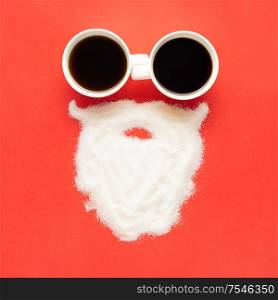Creative concept still life christmas new year holiday photo of espresso coffee cups mugs drink beverage with santa clause face beard made of sugar on red background.