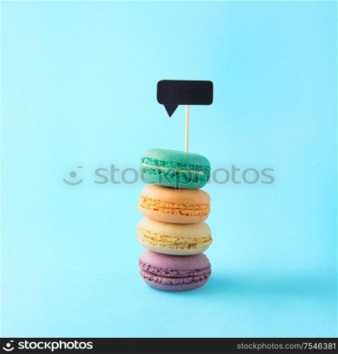 Creative concept still life food diet health photo of macarons macaroons pastry almond sweet confectionary with message cloud notification on blue background.