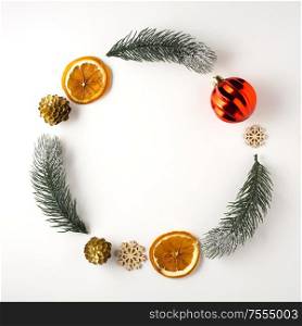 Creative concept still life holiday Christmas photo of pine tree branches and berries in the shape of wreath on white background.
