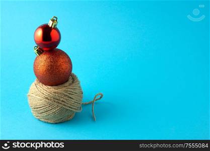 Creative concept still life holiday photo of Christmas toys balls decorations and decorative rope on blue background.