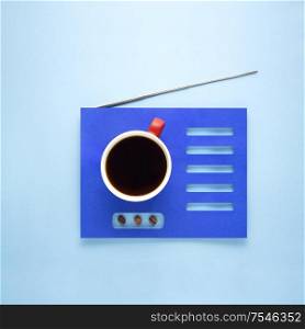 Creative concept still life photo of espresso coffee cup mug drink beverage with beans seeds and radio made of paper on blue background.