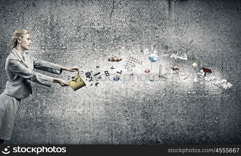 Creative concept. Young businesswoman holding bucket with paint splashes