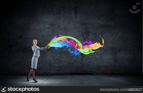 Creative concept. Young businesswoman holding bucket with paint splashes