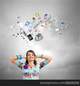 Creative concept. Young woman closing ears with hands and icons flying above