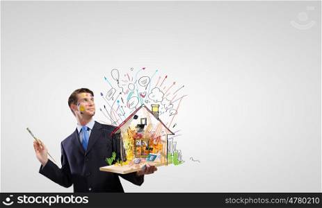 Creative designer. Young businessman holding paint brush in hand