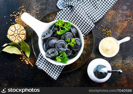 Creative dumplings from black dough, boiled pelmeni