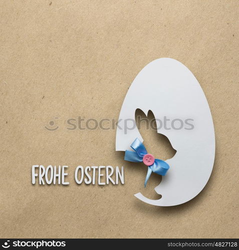 Creative easter concept photo of a rabbit in an egg made of paper on brown background.