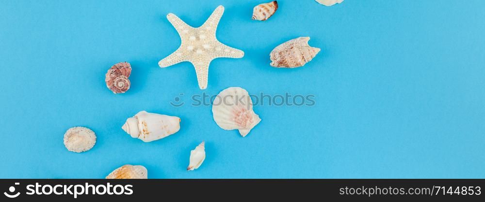 Creative flat lay concept of summer travel vacations. Top view of seashells and starfish on turquoise blue background with postcard mock up and copy space in minimal style, template for text