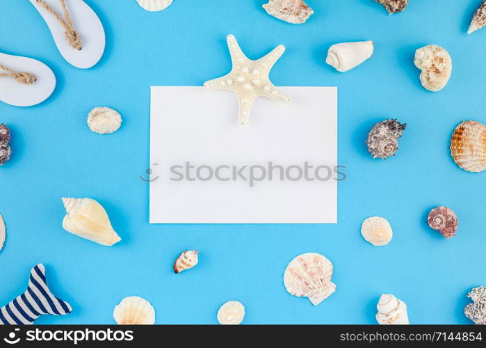 Creative flat lay concept of summer travel vacations. Top view of seashells and starfish on turquoise blue background with postcard mock up and copy space in minimal style, template for text