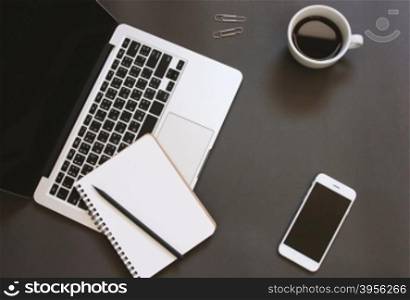 Creative flat lay design of workspace desk with laptop, notebook, smartphone and coffee with copy space background