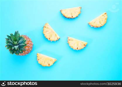 Creative flat lay exotic summer fruit design, pineapple slice on blue color background