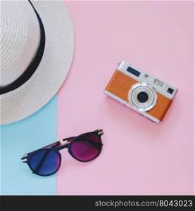 Creative Flat lay fashion style with camera, sunglasses and panama hat on pastel color background&#xA;