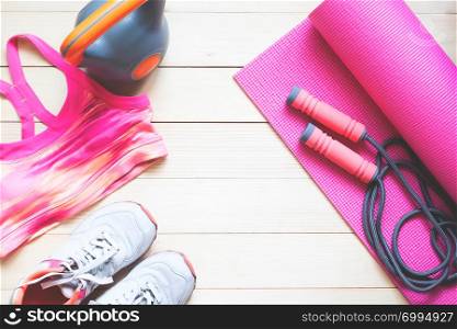 Creative flat lay healthy and dieting concept. Fitness equipments and cloting in pink colour tone