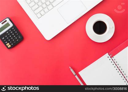 Creative flat lay of Business and Online shopping concept, laptop computer, cup of coffee, calculator and notebook on red color background, Workspace, Online marketing