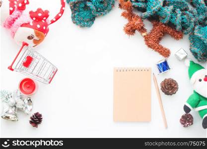 Creative flat lay of christmas decorations with blank notebook and shopping cart on white background