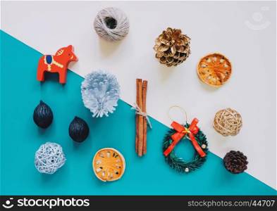 Creative flat lay of christmas ornaments and craft objects in minimal style on colorful background, top view