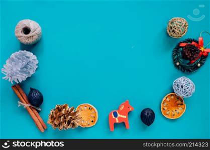 Creative flat lay of christmas ornaments in minimal style with copy space on green background, holiday concept