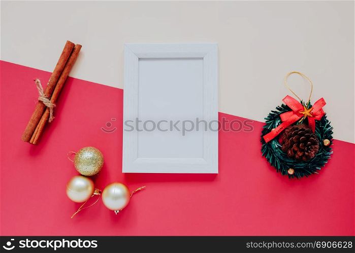 Creative flat lay of craft and photo frame mock up with christmas ornaments on colorful background, minimal style