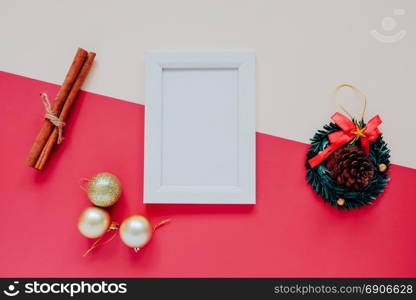 Creative flat lay of craft and photo frame mock up with christmas ornaments on colorful background, minimal style