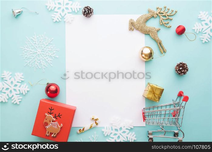 Creative flat lay of Gift box and ornaments with blank paper for text on pastel color background, Merry Christmas and Happy New Year concept