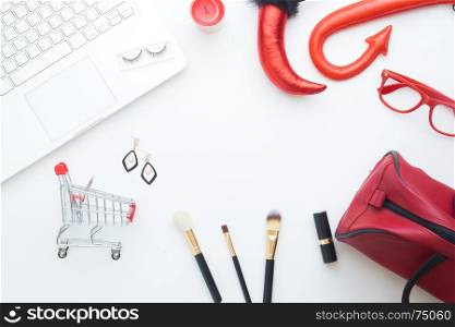 Creative flat lay of Halloween and fashion concept with laptop and shopping cart on white background, Online shopping