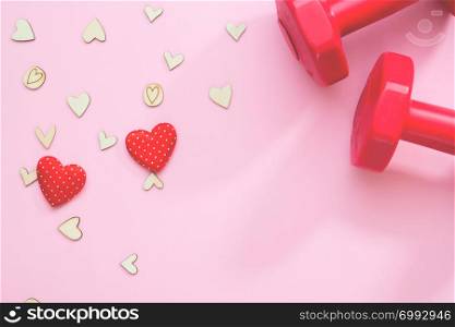 Creative flat lay of health or insurance concept. Hearts and fitness equipment on pink background