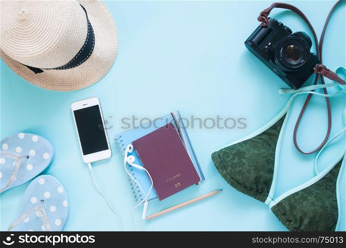Creative flat lay of passport, camera and woman accessories on pastel color background, summer vacation lifestyle