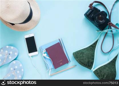 Creative flat lay of passport, camera and woman accessories on pastel color background, summer vacation lifestyle