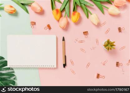Creative flat lay of travel vacation spring or summer tropical fashion. Top view beach accessories open mockup black notebook for text on pastel background. Top view mock up copy space photography.