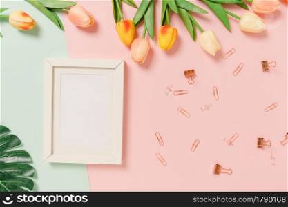 Creative flat lay of travel vacation spring or summer tropical fashion. Top view beach accessories open mockup black frame for text on pastel background. Top view mock up copy space photography.