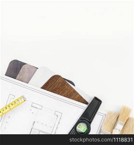 Creative flat lay overhead top view blueprint flat project plan and office supplies on decorator table workspace swatches tools and equipment background copy space concept