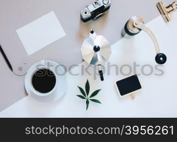 Creative flat lay photo of coffee workspace with coffee maker, coffee grinder, black coffee, film camera, blank card with copy space background, minimal style&#xD;