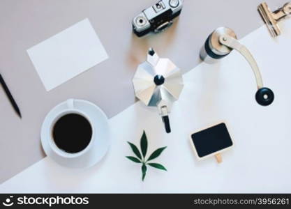 Creative flat lay photo of coffee workspace with coffee maker, coffee grinder, black coffee, film camera, blank card with copy space background, minimal style&#xD;