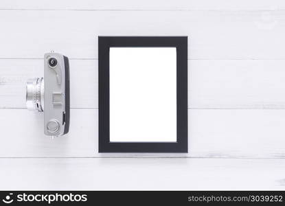 Creative flat lay photo of workspace desk. Office desk wooden ta. Creative flat lay photo of workspace desk. Office desk wooden table with old camera and poster mockup template. Top view with copy space. Top view of old camera over wooden table. Retro vintage filter